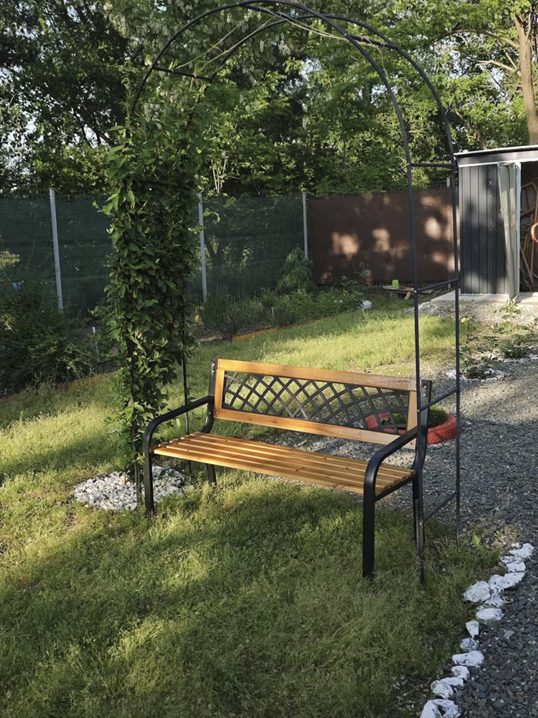 Bancă de grădină sub o arcadă cu plante