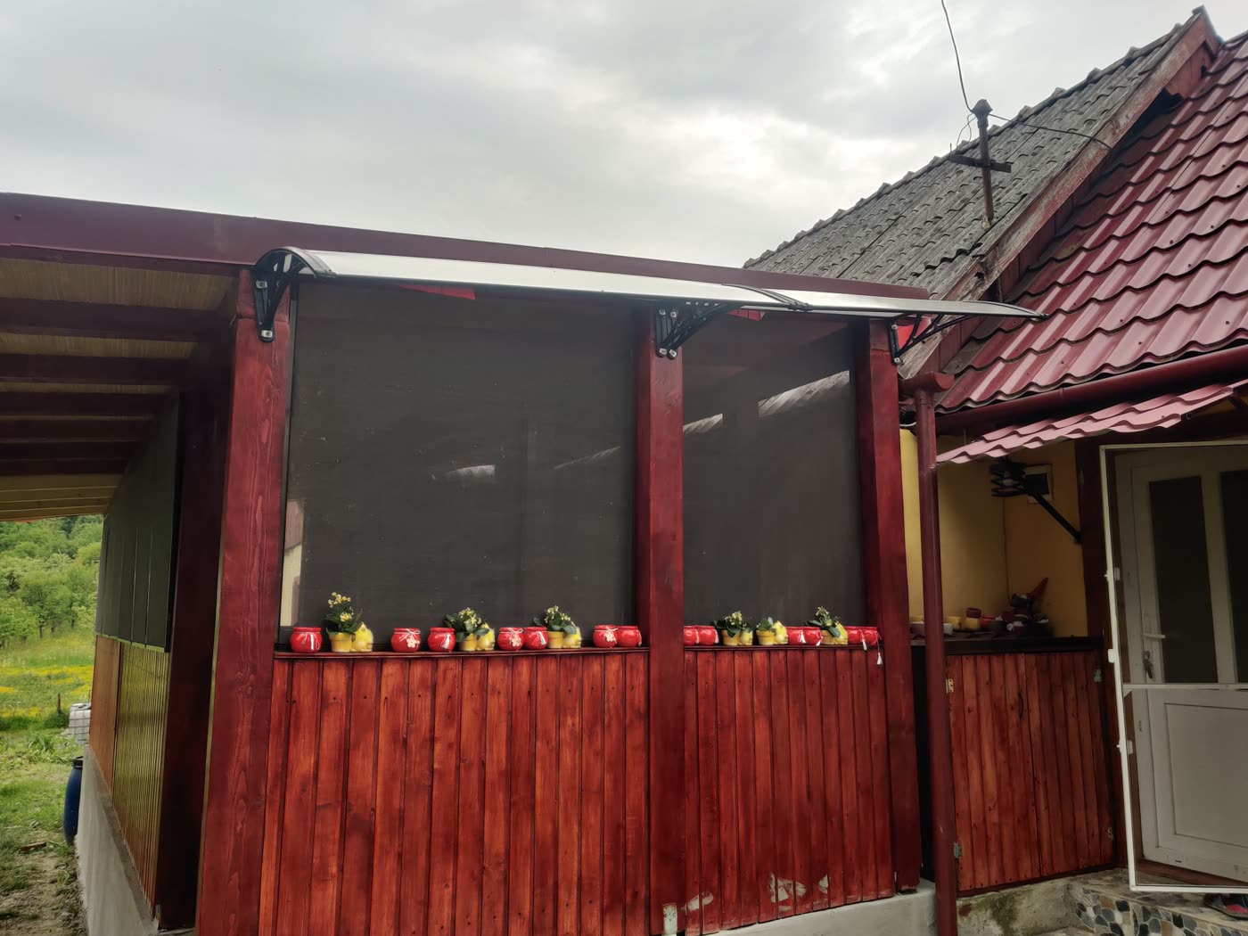 Copertină transparentă montată pe un pridvor din lemn